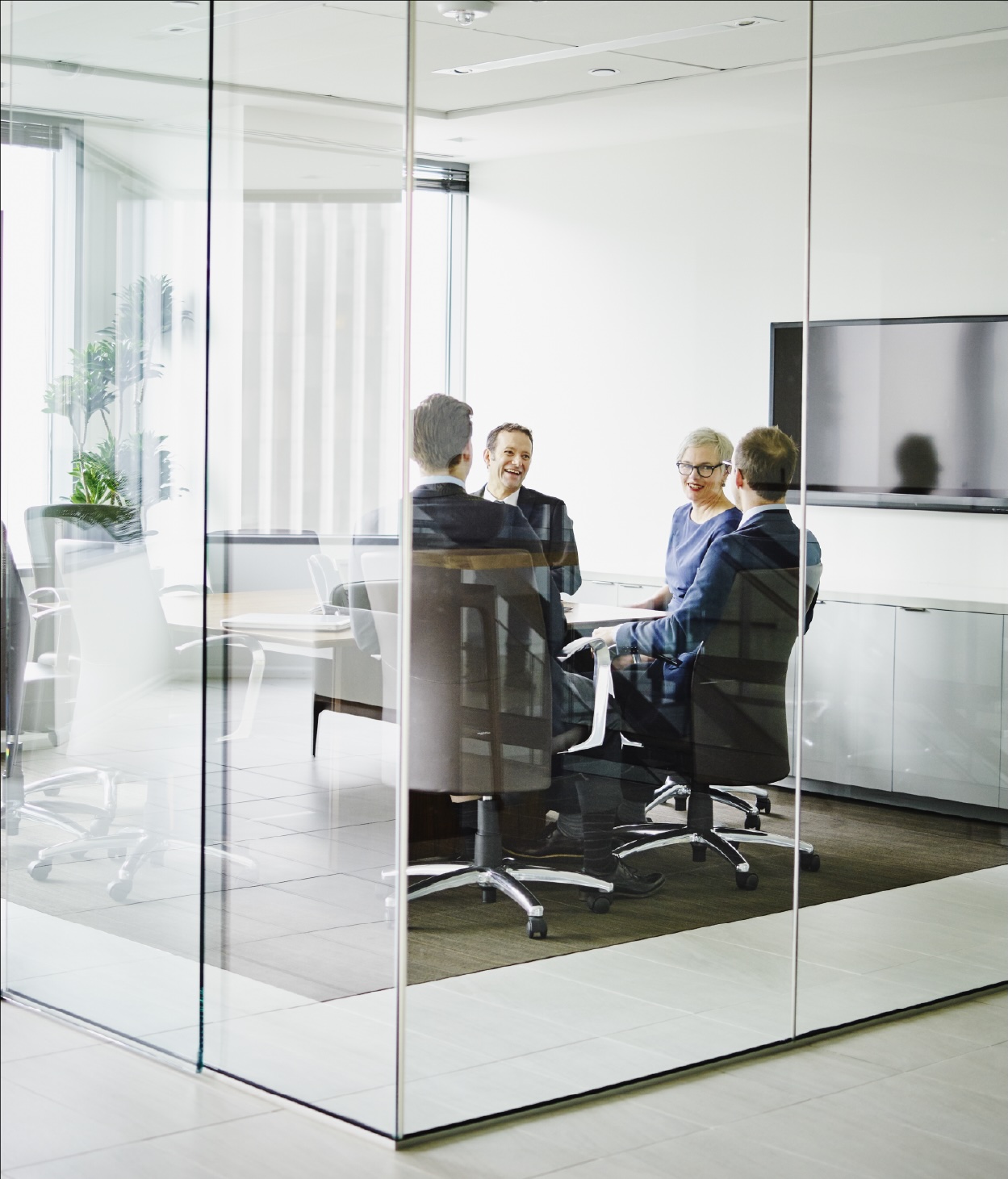 Professionals in business outfits hold a conference in a modern office room
